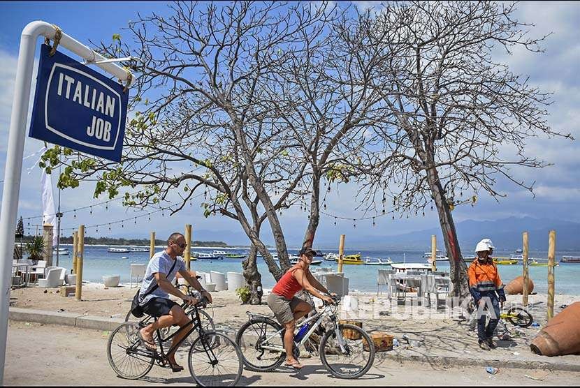 Dua orang wisatawan asing mengendarai sepeda di kawasan wisata Gili Trawangan, Desa Gili Indah, Kecamatan Pemenang, Tanjung, Lombok Utara, NTB.