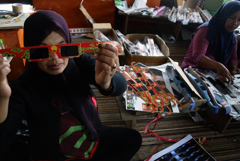 Dua pekerja menyelesaikan pembuatan kacamata untuk melihat gerhana matahari total di Imah Noong TokoTeleskop, Lembang, Kabupaten Bandung Barat. Jawa Barat, Selasa (1/3).