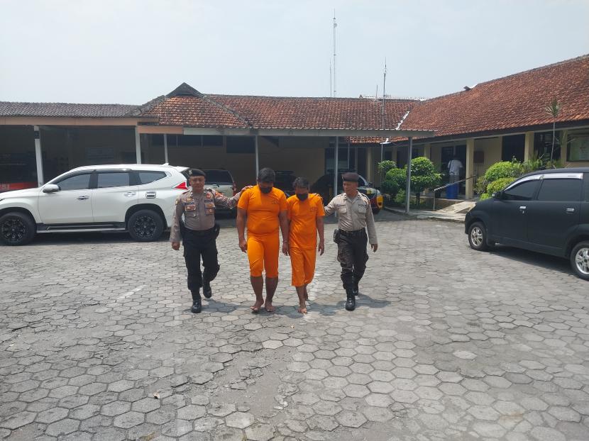 Dua pelaku pencurian mobil vallet di Sleman (tengah) dikawal anggota Polresta Sleman, Rabu (22/3/2023).
