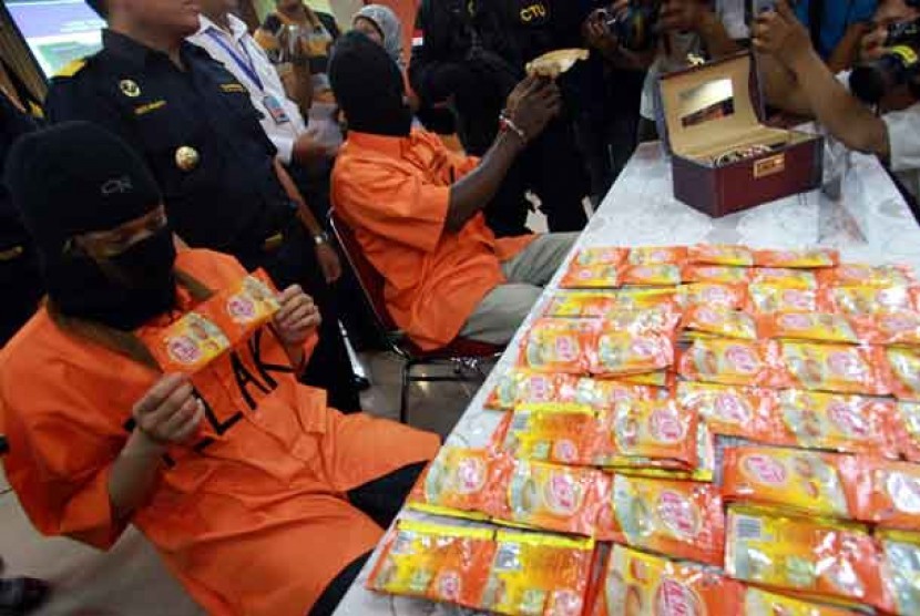 Dua pelaku penyelundupan sabu yang dikemas dalam sachet kopi,seorang Wanita WN China berinisial MF (26) dan D (20) WN Afrika menunjukkan barang bukti kejahatan di kantor Bea Cukai Bandara Soekarno Hatta, Tangerang, Banten, Senin (21/1). 