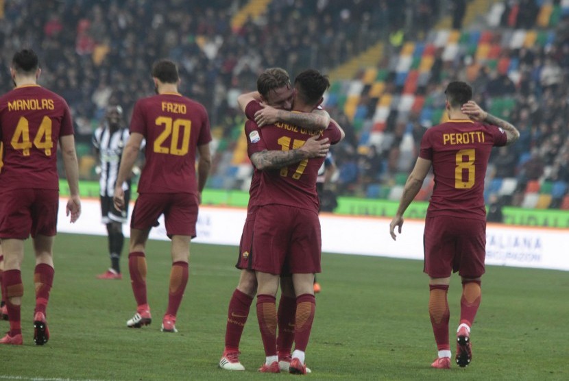 Dua pemain AS Roma, Cengiz Under dan Danielle de Rossi (tengah) berpelukan merayakan gol ke gawang Udinese pada laga Serie A di Darcia Arena, Sabtu (17/2). Roma menang 0-2.