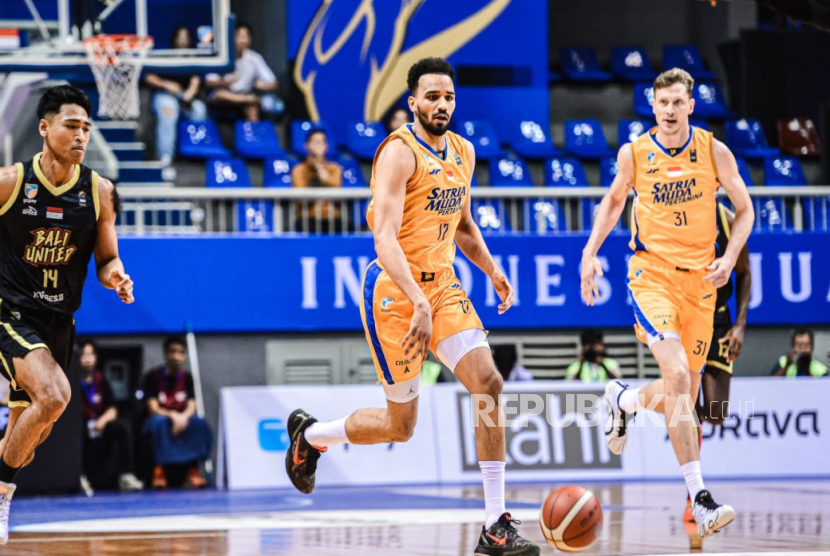 Dua pemain asing Satra Muda Pertamina Amine Noua (tengah) dan Artem Pustovyi (kanan) dalam pertandingan IBL 2025 melawan Bali United Basketball di Britama Arena, Kelapa Gading, Jakarta, Jumat (13/6/2025).