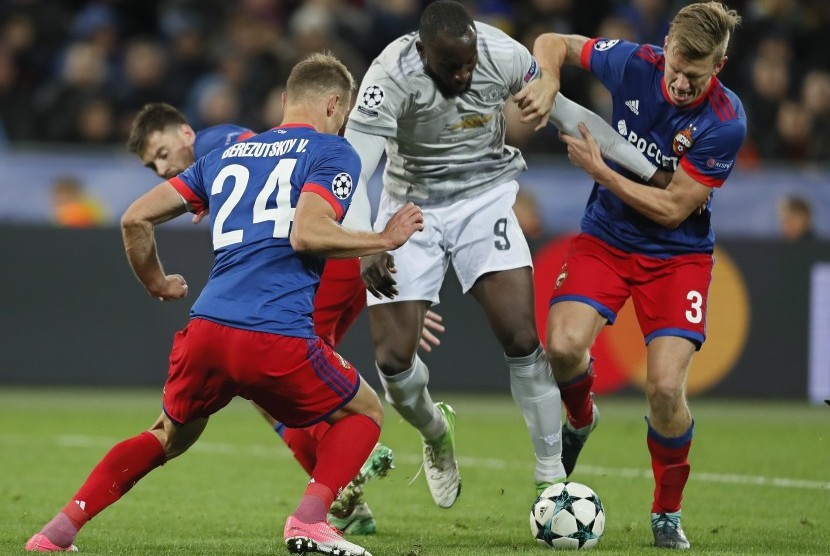 Dua pemain CSKA Moskow, Vasili Berezutski (kiri) dan Pontus Wernbloom (kanan), berusaha mengadang striker Manchester United Romelu Lukaku ketika kedua tim saling berhadapan pada Liga Champions Grup A di VEB Arena, Moskow, Rusia, Kamis (28/9) dini hari WIB. 