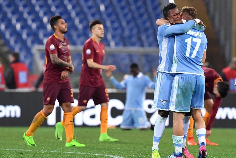 Dua pemain Lazio berpelukan seusai laga melawan AS Roma di Stadion Olimpico, Kamis (2/3) dini hari WIB. Lazio menang 2-0 pada leg pertama semifinal Coppa Italia ini.