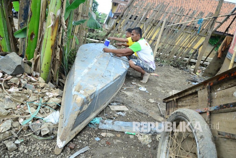 Dua penduduk mempersiapkan perahunnya di lokasi yang biasa terendam banjir di daearah Cieunteung, Dayeuhkolot, Kabupaten Bandung, Kamis (22/9). (Republika/Edi Yusuf)