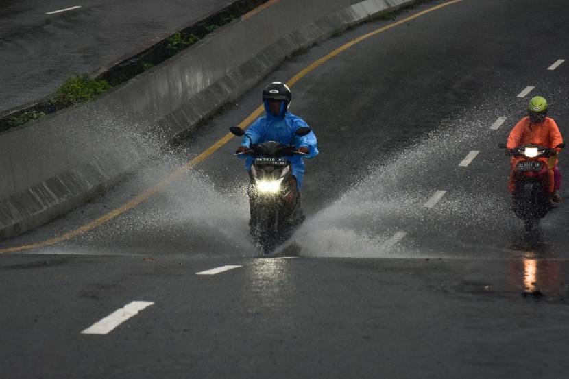 Dua pengendara melaju menembus hujan di Jalan Jenderal Sudirman, Kota Ambon, Maluku, Senin (11/7/2022). Cuaca Hari Ini: Hujan Diprakirakan Turun di Sejumlah Kota Besar