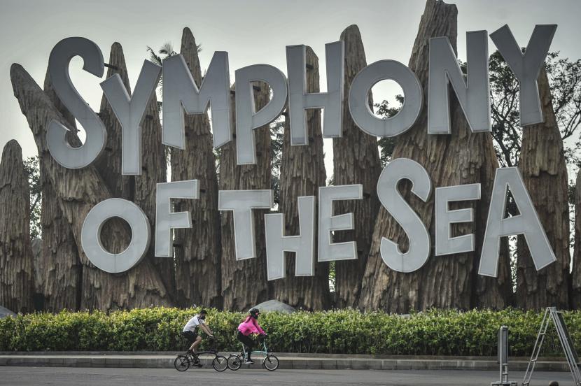 Dua pengunjung bersepeda di kawasan Taman Impian Jaya Ancol, Jakarta. Saat ini Pemerintah Provinsi (Pemprov) DKI Jakarta menerapkan Pemberlakuan Pembatasan Kegiatan Masyarakat (PPKM) Level 3. Meski Ibu Kota telah turun dari level 4, tetapi tempat wisata masih belum boleh beroperasi. 