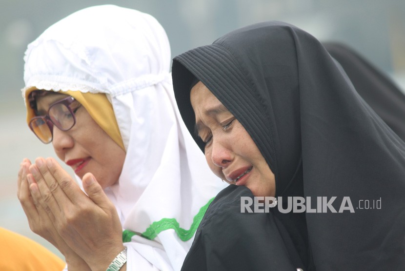 Dua perempuan menangis seusai melaksanakan Sholat Istisqa (salat minta hujan) di halaman Makodam XII/Tanjungpura di Kabupaten Kubu Raya, Kalbar, Selasa (17/9/2019).