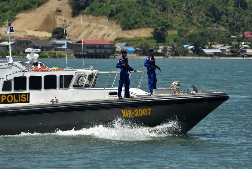 Dua personil kapal patroli C2 BKO Airud Polda Sulteng bersenjata lengkap bersiaga saat berpatroli di perairan Poso, di Poso, Sulawesi Tengah, Rabu (18/3).