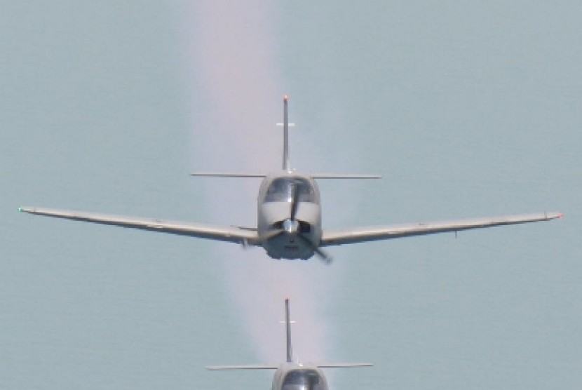 Dua pesawat latih Bonanza milik Skuadron Udara 200 Wing Udara 1 Puspenerbal, melakukan terbang formasi dan beratraksi mengeluarkan asap.