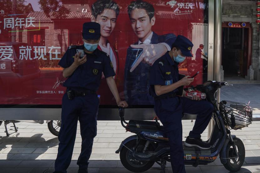 Dua petugas berdiri di salah satu jalanan di Beijing, China. Pada Jumat (12/6) muncul kasus baru di Beijing setelah nol kasus selama dua bulan.