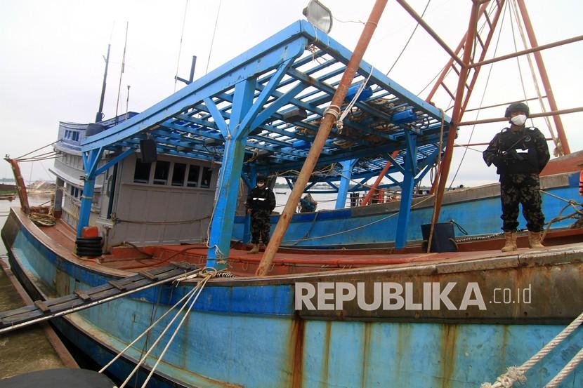 Dua petugas Kapal Pengawas Kementerian Kelautan dan Perikanan (KKP) bersiaga di salah satu Kapal Ikan Asing (KIA) ilegal hasil tangkapan 