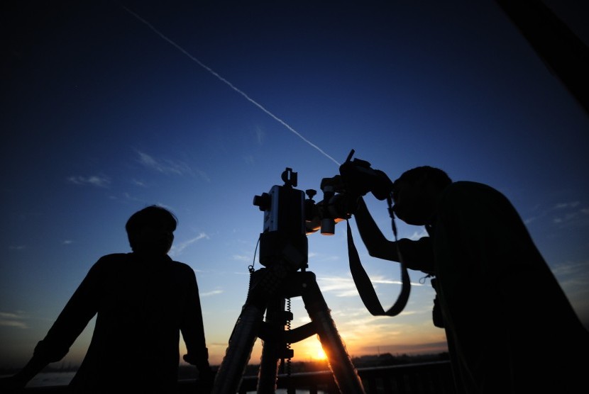 Dua petugas Lapan menyiapkan teleskop untuk pengamatan gerhana matahari total (GMT) di Jembatan Ampera, Palembang, Selasa (8/9).