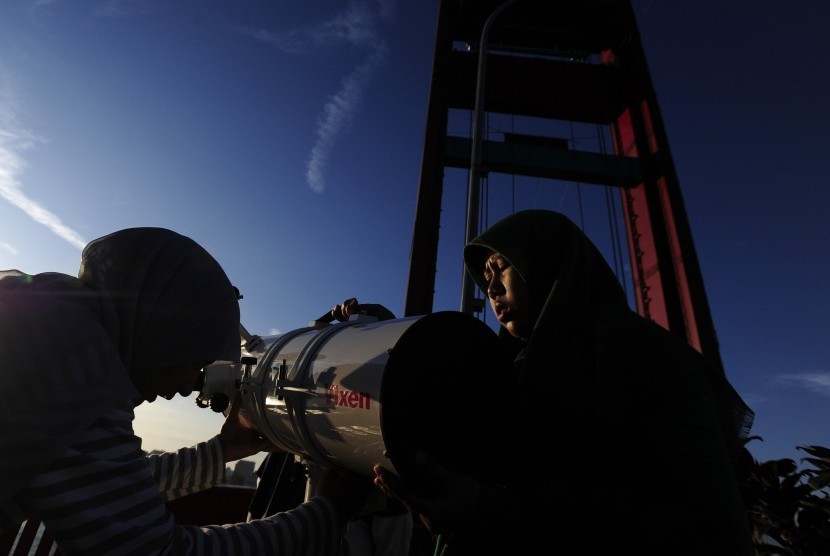 Dua petugas Lapan menyiapkan teleskop untuk pengamatan gerhana matahari total (GMT) di Jembatan Ampera, Palembang, Selasa (8/9). 