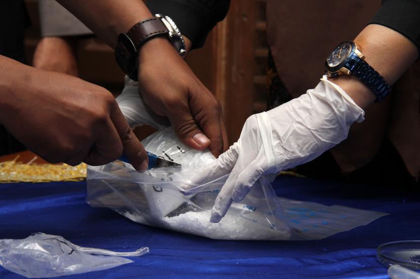 Dua petugas mengeluarkan barang bukti narkotika jenis sabu untuk dilakukan uji kadar narkotika saat rilis kasus di Badan Narkotika Nasional (BNN) Kalimantan Barat di Pontianak, Kalimantan Barat, Rabu (18/5/2022). (Ilustrasi)