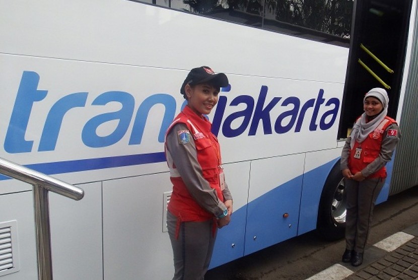  Dua petugas Transjakarta di samping logo baru Transjakarta yang resmi diluncurkan usai upacara Hari Pahlawan 10 November di Lapangan Barat Monas, Jakarta, Senin (10/11).