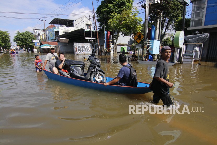Dua pria menarik perahu yang disewakan untuk mengangkut warga dan motor dari kawasan Jalan A Yani yang terendam banjir di Samarinda, Kalimantan Timur, Rabu (12/6/2019).