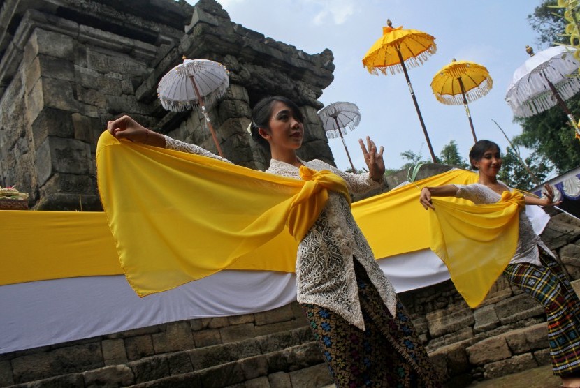 Dua seniman membawakan tari Rejang sebelum diadakan upacara Ngembak Geni di Candi Badut, Malang, Jawa Timur, Kamis (10/3).