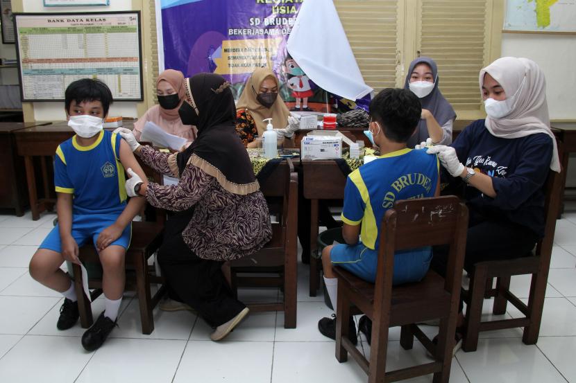 Dua siswa disuntik vaksin saat giat vaksinasi oleh Polda Kalbar di Sekolah Dasar Bruder Dahlia, Pontianak, Kalimantan Barat, Sabtu (12/3/2022). Dinas Kesehatan Provinsi Kalbar mencatat hingga Jumat (11/3/2022) cakupan vaksinasi anak fasyankes Kalbar untuk vaksinasi tahap pertama sebesar 46,1 persen dan vaksin tahap kedua sebesar 7,16 persen dengan jumlah sasaran sebanyak 560.949 anak di daerah setempat.