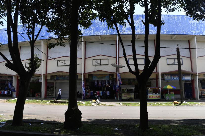 Dua siswa melintas depan kios yang berada di kompleks Stadion Kanjuruhan, Malang, Jawa Timur. 
