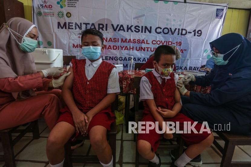 Dua siswa mendapatkan vaksinasi COVID-19 di SD Negeri 8 Menteng Palangkaraya, Kalimantan Tengah, Senin (31/1/2022). Dinas Kesehatan Provinsi Kalteng mencatat capaian pelaksanaan vaksinasi di provinsi tersebut yaitu sebanyak 1,79 juta orang atau 87,7 persen untuk dosis pertama dan 1,079 juta orang atau 57,7 persen untuk dosis kedua dari total target sasaran 2,04 juta orang. 