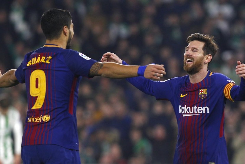 Dua striker Barcelona, Lionel Messi (kanan) dan Luis Suarez merayakan gol ke gawang Real Betis pada laga La Liga di stadion Villamarin, Senin (21/1). Barce menang 5-0.