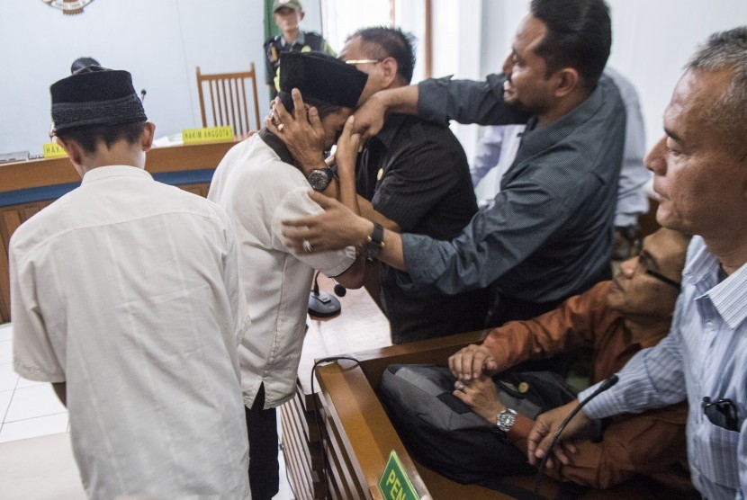 Dua terdakwa pengeroyokan Haringga Sirla yang berinisial AP (kiri) dan NSF (kedua kiri) memeluk pendamping seusai mengikuti sidang pembacaan putusan di Pengadilan Negeri Bandung, Jawa Barat, Selasa (6/11/2018).