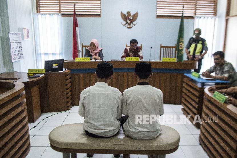 Dua terdakwa pengeroyokan Haringga Sirla yang berinisial AP (kiri) dan NSF (kanan) mengikuti sidang pembacaan putusan di Pengadilan Negeri Bandung, Jawa Barat, Selasa (6/11)