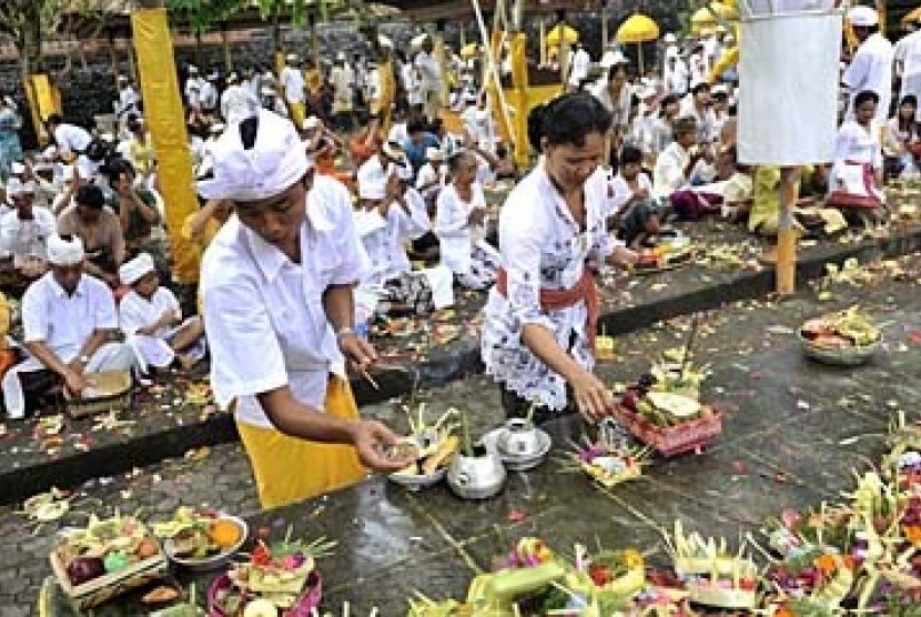Dua umat Hindu menyiapkan sesajen dalam perayaan hari suci Kuningan (ilustrasi)