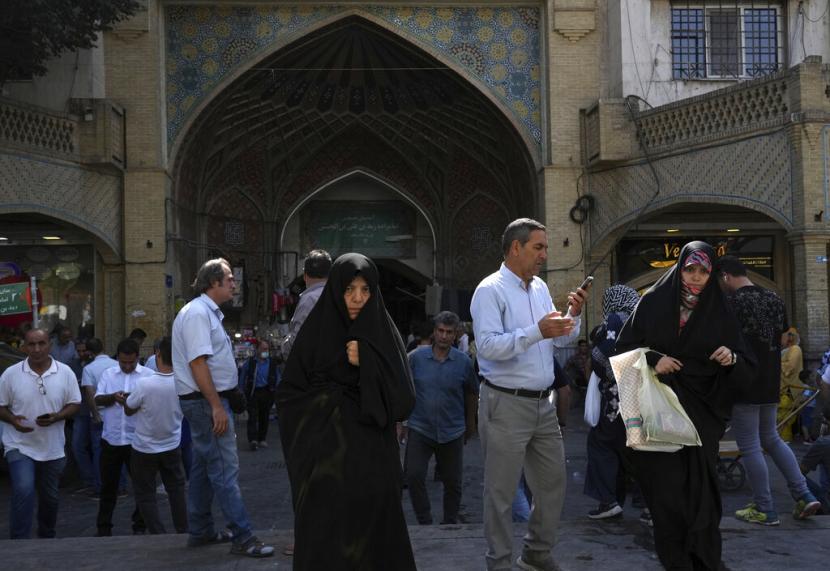 Dua wanita berjalan-jalan di bazaar tua Teheran dengan pakaian Islami dari ujung kepala hingga ujung kaki, Iran, Sabtu, 1 Oktober 2022. Ribuan warga Iran turun ke jalan selama dua minggu terakhir untuk memprotes kematian Mahsa Amini, seorang wanita berusia 22 tahun yang telah ditahan oleh polisi moral di ibukota Teheran karena diduga mengenakan jilbab wajibnya terlalu longgar.