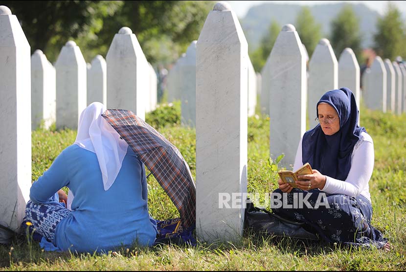 Dua wanita Bosnia membacakan doa di Potocari Memorial Center Srebrenica Bosnia Herzegovina di sela peringatan 22 tahun pembantaian ribuan muslim Bosnia oleh tentara Serbia.