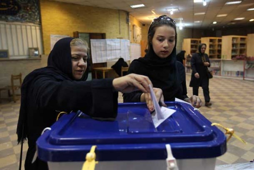 Dua wanita Iran memberikan suara mereka saat pemilihan presiden Iran di Teheran, Jumat (14/6).