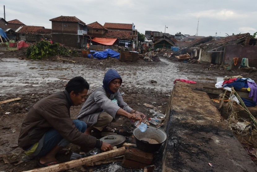 Dua warga beraktivitas di lokasi bangunan yang rusak akibat banjir bandang aliran Sungai Cimanuk di Kampung Cimacan, Tarogong, Kabupaten Garut, Jawa Barat, Jumat (23/9). 