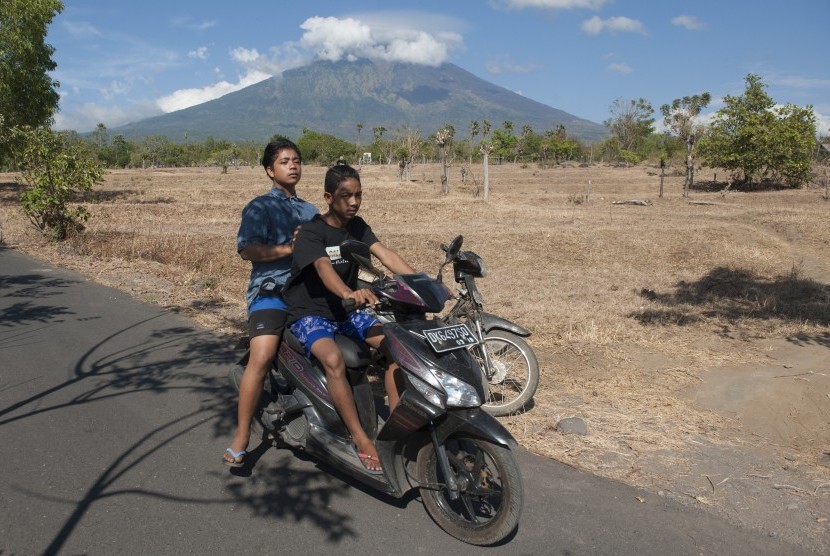 Dua warga di jalan Desa Datah yang berjarak sekitar 10 kilometer dari Gunung Agung yang berstatus awas di Karangasem, Bali, Selasa (26/9).