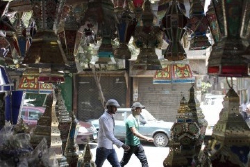 Dua warga melintasi toko yang dipenuhi lentera tradisional di Cairo, Mesir (ilustrasi)