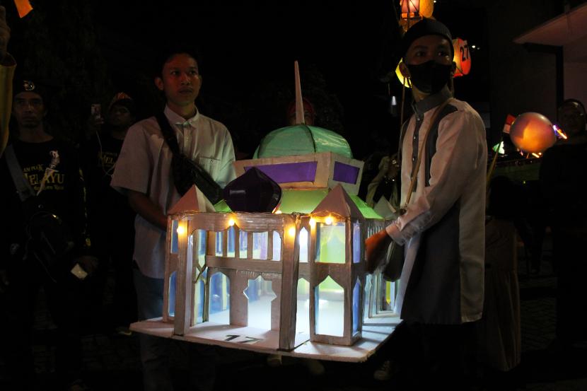 Dua warga membawa tanglong atau lampion berbentuk miniatur masjid yang dihiasi lampu elektrik saat mengikuti Festival Tanglong Khatulistiwa di Pontianak, Kalimantan Barat, Ahad (24/4/2022) malam. Naskah Khutbah Jumat: Refleksi Akhir Safar, Songsong Datangnya Maulid