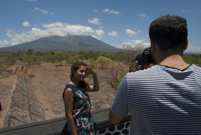 Two tourists photographed with the background of Mount Agung, in the village of Batu Niti which is about 12 kilometers from the status of the mountain, Karangasem, Bali, Monday (September 25).