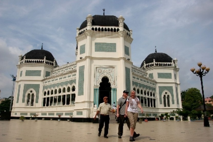 Dua wisatawan mancanegara bersama seorang pemandu ketika mengunjungi Masjid Raya Al-Mashun, Medan, Sumut, Selasa (5/6). Pihak Dinas Kebudayaan dan Pariwisata Kota Medan menyatakan, kunjungan wisatawan mancanegara ke Medan meningkat 20 persen dari bulan seb