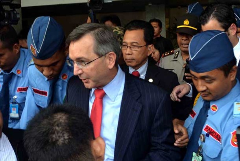 The US Ambassador to Indonesia, Scot Marcie, is escorted by security guards from the House of Representative as well as the embassy while leaving the parliament complex in Senayan, Jakarta, on Monday.