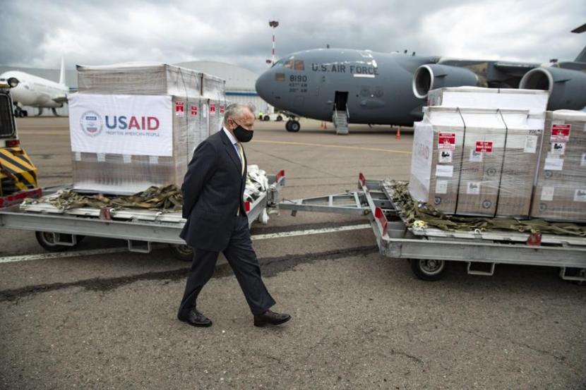 Duta Besar Amerika Serikat (AS) untuk Rusia, John Sullivan  berjalan melewati paket bantuan medis dari Amerika Serikat untuk penanganan Covid-19, di Bandara Internasional Vnukovo di luar Moskow, Rusia, 4 Juni 2020. Dia telah meminta warga AS untuk segera meninggalkan Rusia.