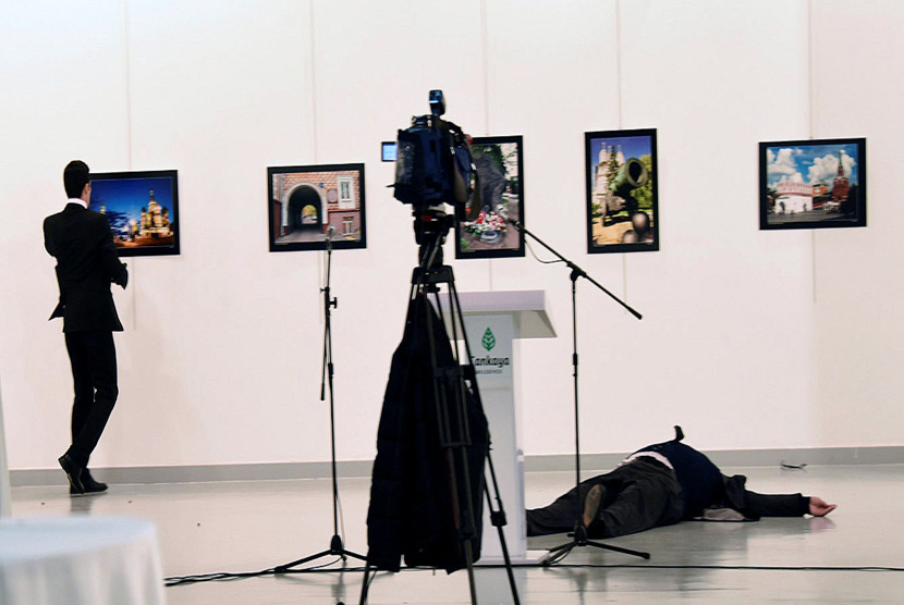 Duta Besar (Dubes) Rusia untuk Turki Andrei Karlov tergeletak dilantai  setelah ia ditembak oleh Mevlut Mert Altintas (kiri) di sebuah galeri seni di Ankara, Turki, 19 Desember 2016. 