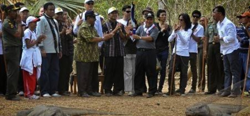 Duta Komodo, Jusuf Kalla (tengah), menerima obor api Sea Games ke-26 dari Wakil Gubernur NTT, Esthon L.Feonay, di Pulau Komodo, Nusa Tenggara Timur (NTT), Rabu (26/10). 
