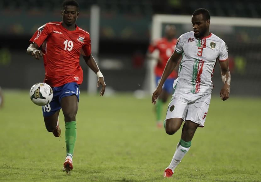 Ebrima Colley dari Gambia (kiri) mengontrol bola saat pertandingan Piala Afrika 2022. Gambia memastikan lolos ke perempat final untuk menantang tuan rumah Kamerun.
