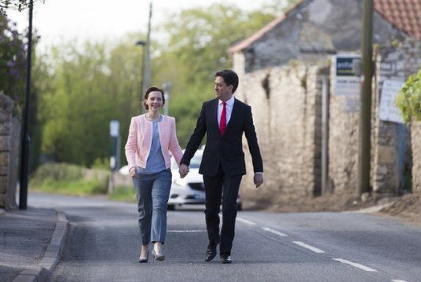 Ed Milliband bersama istrinya Justine berjalan menuju tempat pemungutan suara di Sutton Village Hall di Doncaster, Kamis (7/5).