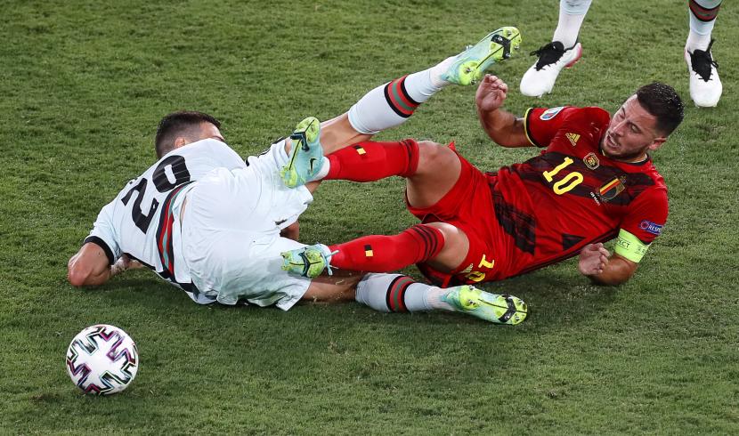 Eden Hazard (kanan) dari Belgia beraksi melawan Diogo Dalot (kiri) dari Portugal selama pertandingan sepak bola babak 16 besar Euro 2020 antara Belgia dan Portugal di Sevilla, Spanyol, 27 Juni 2021. 