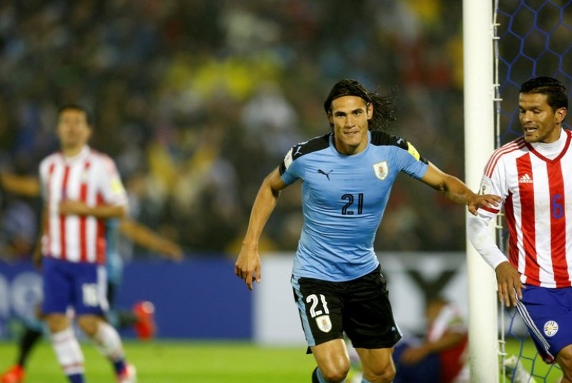Edinson Cavani (biru langit) merayakan golnya ke gawang Paraguay.