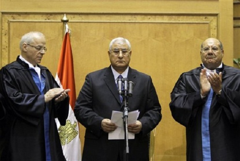 Egypt's chief justice Adly Mansour, center, is applauded by by chiefs of the constitutional court after he is sworn in as the nation's interim president Thursday, July 4, 2013. 