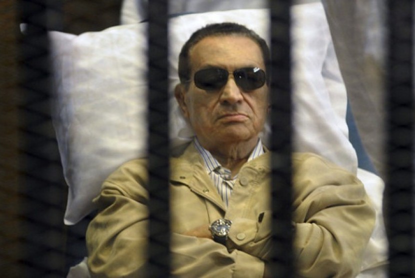 Egypt's ex-President Hosni Mubarak lays on a gurney inside a barred cage in the police academy courthouse in Cairo, Egypt.   
