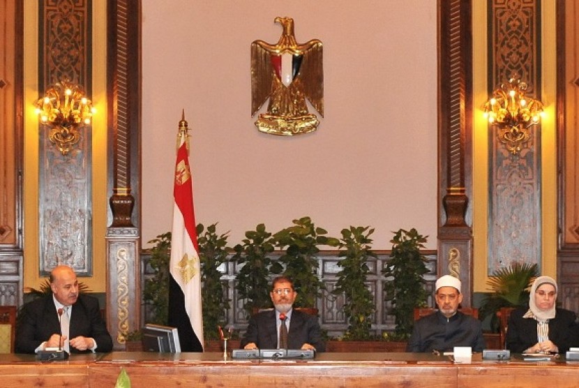 Egypt's President Mohamed Mursi (center) attends a meeting with Egypt's Vice President Mahmoud Mekky (left) with other politicians and heads of parties at the presidential palace in Cairo December 8, 2012. Mursi offers concession by cancelling a decree which has sparked huge protests by giving him sweeping powers. 