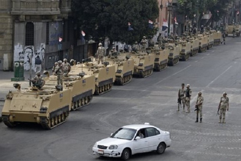 Egyptian army soldiers take their positions on top and next to their armored vehicles while guarding an entrance to Tahrir Square, in Cairo, Friday, Aug. 16, 2013. The price of oil rose for the sixth straight day Friday on continuing violence in Egypt and 